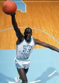 a basketball player reaching up to dunk the ball