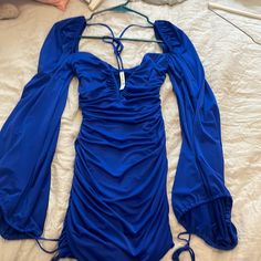 a blue dress laying on top of a bed