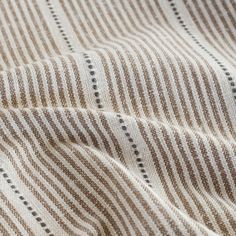 a close up view of a brown and white striped fabric with black dots on it