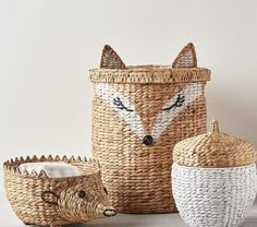 three baskets with animals painted on them and one has a basket in the shape of a fox