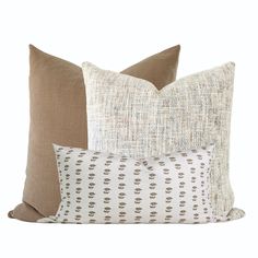 three pillows with different patterns on them, one in brown and the other in white