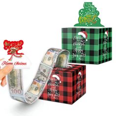 a hand holding a roll of money in front of three christmas gift boxes