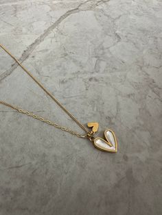 The double heart necklace features a white pearlescent heart and a little gold heart next to it. Perfect for gifting! Measurements: Height: 1.1cmWidth: 1.3 cm Gold Double Heart Charm Necklace, Gold Heart Necklace With Pearl Charm As Gift, White Necklace For Valentine's Day, Trendy Double Heart Charm Necklace, White Initial Pendant Necklace With Delicate Chain, White Heart Pendant Necklace With Delicate Chain, White Heart Charm Jewelry For Everyday, Dainty White Heart Pendant Necklace, Dainty White Heart-shaped Necklace