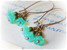 Three little mint opal flowers, dangle beneath elongated kidney wires.. These long earrings are lightweight and fun to wear. Made of Czech glass flower beads, and antiqued brass findings, the length is 1-11/18inches (44mm) including the earring wires. Enter my shop here: https://www.etsy.com/shop/karmelidesigns Green Flower Earrings, Czech Beads Jewelry, Dainty Dangle Earrings, Mint Green Flowers, Purple Drop Earrings, Lavender Earrings, Flower Drop Earrings, Porcelain Earrings, Black Earrings Dangle