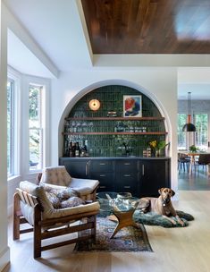 a dog laying on the floor in front of a living room with built - in bookshelves