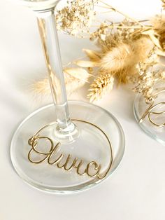 two wine glasses sitting next to each other with the word juice written in gold on them