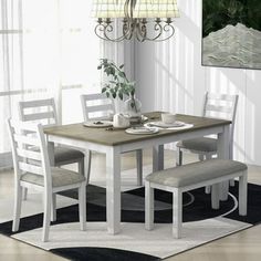 a dining room table with four chairs and a bench