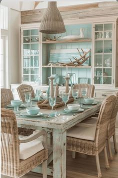 a dining room table and chairs with blue glassware on it in front of a hutch