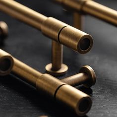 several brass pipes are lined up on a black surface