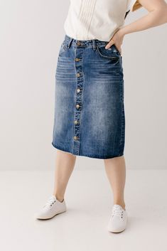 The perfect combination of vintage and feminine - the 'Hilda' denim skirt walked straight out of the 90's into your closet! A distressed denim skirt is one of our favorite staple pieces and the details on this one are exceptional! Quality no stretch denim, a slight A-line style, functioning pockets, brass buttons, and a raw hem. Easily transitional; you can wear it with sandals and your favorite tee for the summer or pair it with a sweater and boots for the fall! Exclusively designed by us for y Classic Mid-rise Denim Blue Denim Skirt, Classic Medium Wash Mid-rise Denim Skirt, Classic Mid-rise Denim Blue Skirt, Classic Mid-rise Medium Wash Denim Skirt, Classic Denim Blue Denim Skirt, Classic Denim Skirt In Denim Blue, Classic Denim Blue Skirt, Classic High Rise Dark Wash Denim Skirt, Fall Dark Wash Washed Denim Skirt