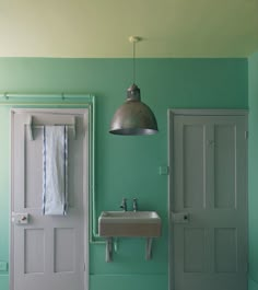 a bathroom with green walls and two sinks