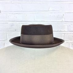 Size 6 7/8 Vintage 1950s 1960s Adam Hats Carbon Brown Porkpie Fedora Hat For your consideration we have a vintage fedora from the ‘50s/‘60s. Made by Adam Hats from a “carbon brown” fur felt, this “Rugby” model features a telescopic crown, brown grosgrain band and edge, leather sweatband, and rayon lining. There are a few spots on the hat band and a few stitches have come out of the leather sweatband. This is still a great hat and wonderful for anyone into slick bop midcentury style.Measurements; Retro Winter Fedora With Curved Brim, Vintage Wool Felt Hat With Flat Crown, Retro Curved Brim Felt Hat For Winter, Brown Fitted Felt Hat With Flat Crown, Fitted Brown Felt Hat With Flat Crown, Retro Adjustable Felt Hat With Flat Brim, Retro Winter Hat With Flat Brim, Brown Felt Hat With Flat Crown, Retro Flat Brim Winter Hat