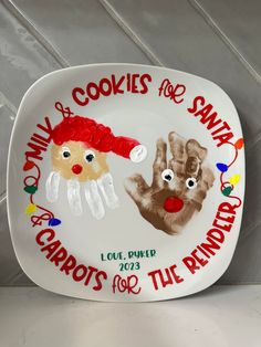 a plate with two handprints on it that says santa carol's cookies for santa