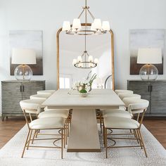 a dining room table with chairs and a large mirror in the middle of the room