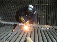 welder working on metal structure with sparks