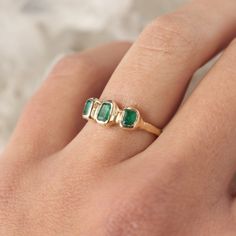 Three emeralds are embedded into this magical piece of treasure! Bezel set in 14k gold, this ring is inspired by ancient jewelry. Currently size 5.5 Due to the nature of the settings, this ring can only be resized up or down 1 size, if you need a size that is outside of the 1 size range, email me! Depending on my stock, I can make you a custom ring in any size! The inclusions and imperfections on these stones are natural. I choose to use perfectly imperfect stones because of the personality they Heirloom Style Emerald Open Ring, Heirloom Style Open Emerald Ring, Emerald Ring With Bezel Setting For May Birthstone, Heirloom Style Emerald Open Ring In Yellow Gold, Heirloom Emerald Open Ring In Yellow Gold, Heirloom Yellow Gold Emerald Open Ring, Heirloom Emerald Ring With Bezel Setting For May Birthstone, Timeless Green Open Ring Emerald, Heirloom Emerald Ring With Bezel Setting