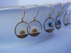 These small round brass frames that are evocative of the sun on the horizon hang from 24k gold plated ear hooks. Available in your choice of real preserved botanical: Queen Anne's Lace is a symbol of sanctuary The Daisy is a symbol of hope Forget-me-nots are known as a symbol of lasting friendship, love, and remembrance Materials are tarnish resistant. However, please see our care section for info on keeping your piece lovely for years to come. All materials are nickel and lead free. Ships in a Nature-inspired Nickel Free Round Earrings, Nickel-free Round Nature-inspired Earrings, Nature-inspired Round Hoop Earrings For Gift, Nature-inspired Hoop Earrings As Gift, Handmade Round Brass Flower Earrings, Gold Botanical Earrings With Pressed Flowers, Botanical Gold Earrings With Pressed Flowers, Gold Drop Earrings With Pressed Flowers, Nature-inspired Nickel-free Round Flower Earrings