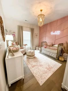 a baby's room with pink walls and white furniture