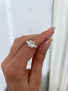 a woman's hand holding an engagement ring