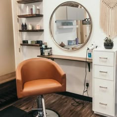 a chair sitting in front of a mirror next to a hair dresser