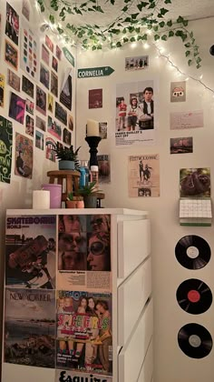 a white refrigerator freezer sitting inside of a kitchen next to a wall covered in pictures