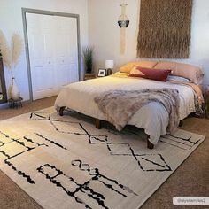 a bed sitting on top of a white rug in a bedroom next to a doorway