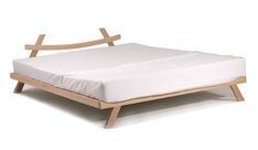 a bed with a wooden frame and white sheets on it's bottom layer, in front of a white background