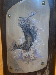 a sign on the side of a wooden pole that has a drawing of a fish on it