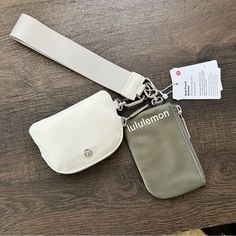 a white purse with a name tag attached to it on a wooden table next to a card holder