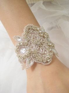 "Intricately beaded applique bracelet made of crystals/rhinestones and silver beads. Combination of marquise crystals, bugle beads and tiny silver beads make up a wonderful French Deco inspired motif and ribbon of your choice is sewn on the applique and ties into a bow. A beautiful, elegant adornment for your wedding or very special occasion attire. A perfect matching headband made of the same applique. http://www.etsy.com/listing/66104328/french-deco-elegant-beaded-silver * Beaded applique meas Silver Crystal Bracelet With Rhinestones, Elegant Beaded Bangle Bracelets With Bling, Elegant Beaded Bangle Bracelet With Rhinestones, Elegant Beaded Bangle Bracelets With Rhinestones, White Crystal Embellished Jewelry, Silver Crystal Embellished Bracelet For Gift, Silver Crystal Embellished Bracelet Gift, Elegant Embellished Silver Jewelry, Silver Crystal Bracelet With Beads For Party