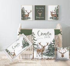 a baby crib bedding set with deer and pine trees on it, next to two pillows