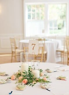 the table is set up with candles and flowers on it for an elegant wedding reception