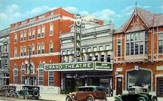 an old painting of cars parked in front of a theater on the corner of a street