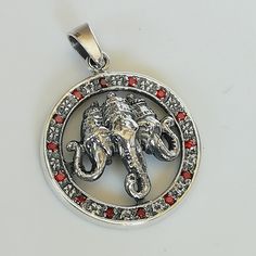 ▪︎ A chunky sterling silver three faced Ganesh pendant. Comes with a round frame studded with red stones. ▪︎ Size: 28 x 32 mm (including jump ring) Weight: 8.2gm ▪︎ This multi purpose pendant can be used as a charm in necklaces, bracelets, key chains, etc. ▪︎ This pendant is handmade with hypoallergenic sterling silver. Most of my pieces are marked with a 925 silver stamp. ▪︎ Please note: This listing is for ONE pendant and comes WITHOUT the chain, however, you can add a snake chain in the requi Symbolic Red Gemstone Jewelry, Symbolic Red Pendant Jewelry, Red Medallion Spiritual Jewelry, Red Spiritual Medallion Jewelry, Silver Amulet Necklaces For Puja, Sterling Silver Pendant For Puja, Ganesh Locket Pendants, Red Sterling Silver Amulet Necklaces, Diamond Ganesh Pendant