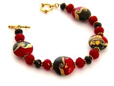 "Christmas Bracelet, Holiday Bracelet in Gold Black and Red, Bracelet Jewelry Gift for Her 8.25 inch Hand made beaded red, black, and gold - red lampwork glass bracelet. I used gold foiled artisan lampwork beads coupled with large cool red Czech crystals and black Czech crystals, interspersed with tiny gold beads. The bracelet closes with an easy-to-use gold plated toggle clasp with a rope motif. Length: 8.25 inches Please leave a note if you need a slight adjustment in length. Arrives with a Ma Red Faceted Beads Bracelet, Traditional Red Faceted Beads Bracelet, Red Czech Glass Bracelets With Colorful Beads, Bohemian Red Bracelets Made Of Czech Glass, Gift Bracelets With Polished Beads And Czech Glass, Bohemian Red Czech Glass Bracelets, Red Czech Glass Spiritual Jewelry, Adjustable Red Czech Glass Bracelets, Adjustable Red Czech Glass Bracelet