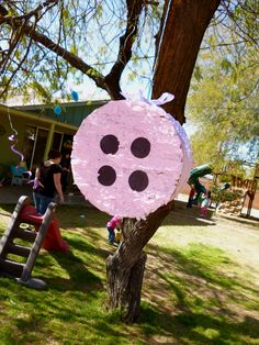 a paper plate shaped like a pig sitting on top of a tree next to a ladder