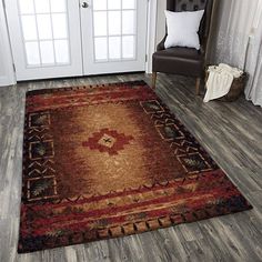 a brown and red rug on the floor in front of a door with a chair