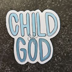 a sticker with the words child god written in blue ink on a black surface