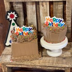 two birthday cakes sitting on top of a wooden chair