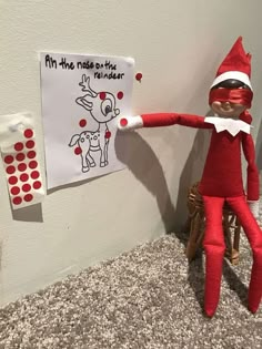 an elf is pointing at a sign on the wall