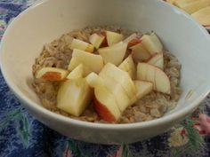 a bowl filled with oatmeal topped with sliced apples