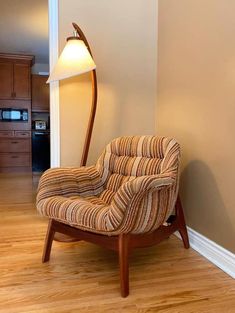 a chair sitting in the corner of a room with a lamp on top of it