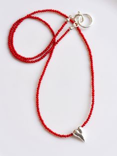 "Long Red Coral Beads Necklace, adorned with a dainty Solid Silver Sculptural Heart Charm. The necklace's versatility allows it to complement a wide range of outfits with ease, while the contrasting hues of the red coral beads and silver heart charm create a stunning focal point. The sculptural design of the silver heart adds a touch of sophistication and elegance to the piece. This necklace is a must-have in your jewelry collection, and it makes the perfect gift for your loved one. THE STORY AB Cheap Red Beaded Necklace With Heart Beads, Red Beaded Necklace, Tiny Heart Necklace, Antique Silver Necklace, Red Beaded Necklaces, Red Coral Necklace, Coral Beads Necklace, Hand Knotted Necklace, Coral And Gold