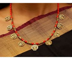 Product Description :  High quality Oxidized Gold Goddess Durga Coins with Red Coral beads Necklace with adjustable necklace dori for perfect fitting. A perfect choice for your jewellery collection. Suitable for Wedding, ethnic wear, festive and party wear. A beautiful gift for your loved ones. This product is especially handmade for you after receiving the order and takes 4 to 5 man hours to complete, hence slight imperfections are expected which is not a defect.  Slight color variation of the product may occur due to photographic light effect. Necklace Weight : 55 gms Dimensions : Necklace Length (w/o dori) - 22 cm, Dori Length - 26 cm Material : Alloy metal, Oxidized Gold, Faux Coral beads Product Care :  Avoid contact with body spray, chemicals & water. Clean with soft cloth after use Red Temple Jewelry Necklace As A Gift, Red Temple Jewelry Necklace For Gift, Red Temple Necklace As Gift, Red Temple Necklace For Gifts, Red Beaded Necklaces For Celebration In Temple Jewelry Style, Red Temple Necklace With Round Beads As Gift, Red Beaded Temple Jewelry Necklaces For Celebration, Red Temple Jewelry Necklace For Diwali, Red Beaded Temple Necklace Gift