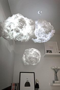 some white clouds are floating in the air above a desk and bookshelf with pictures on it