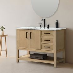 a bathroom vanity with two sinks and a round mirror on the wall next to it