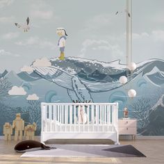 a baby's room decorated in blue and white with an ocean scene painted on the wall