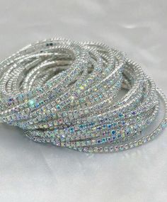 The Jeweled Bracelet Stack is an ultra-fine and fashionable set of 11 elastic bracelets, each covered in dazzling AB rhinestones. Perfect for any occasion, from parties and gatherings to banquets and daily wear, these bracelets add a touch of sparkle and sophistication to any outfit. Designed for women who love to make a statement, this set offers versatile styling options with its eye-catching elegance. Diameter: 2" Trendy Party Bracelets With Rhinestones, Trendy Rhinestone Bracelets For Party, Silver Bracelets With Rhinestones For Party, Silver Stretch Bangle Bracelet For Party, Trendy Rhinestone Crystal Bracelet For Party, Sparkling Dazzling Bracelets For Party, Dazzling Sparkling Bracelet For Party, Trendy Crystal Bracelets For Party, Dazzling Crystal Bracelet With Sparkling Stones For Party