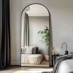 a bedroom with a large mirror on the wall and a bed in front of it