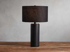 a black table lamp with a brown shade on the base and a dark fabric lampshade